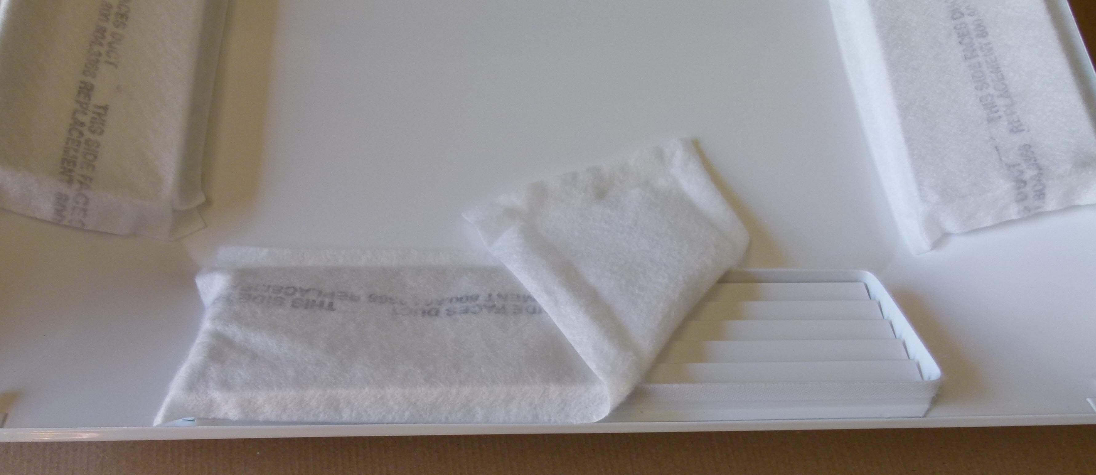 A folded white towel on a white surface.